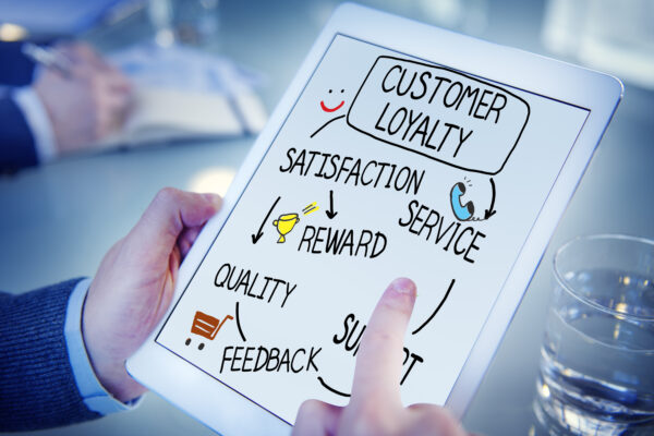 A person holding a tablet with a diagram of customer loyalty programs