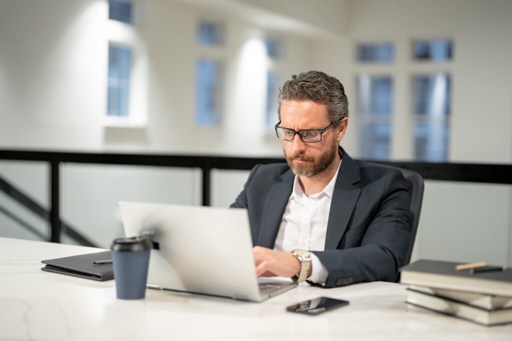 A professional man analyzing customer acquisition strategies while using his laptop.