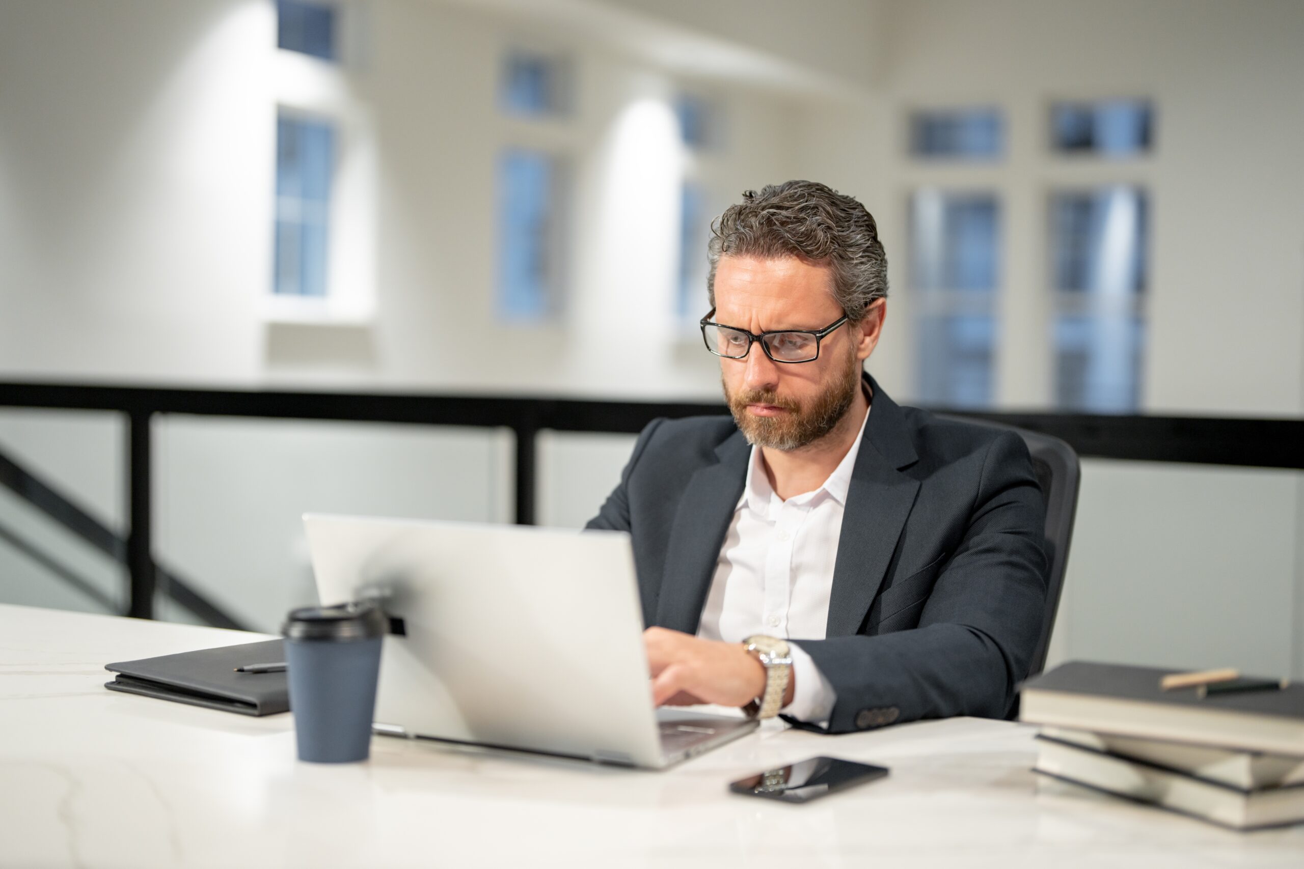 A professional man analyzing customer acquisition strategies while using his laptop.