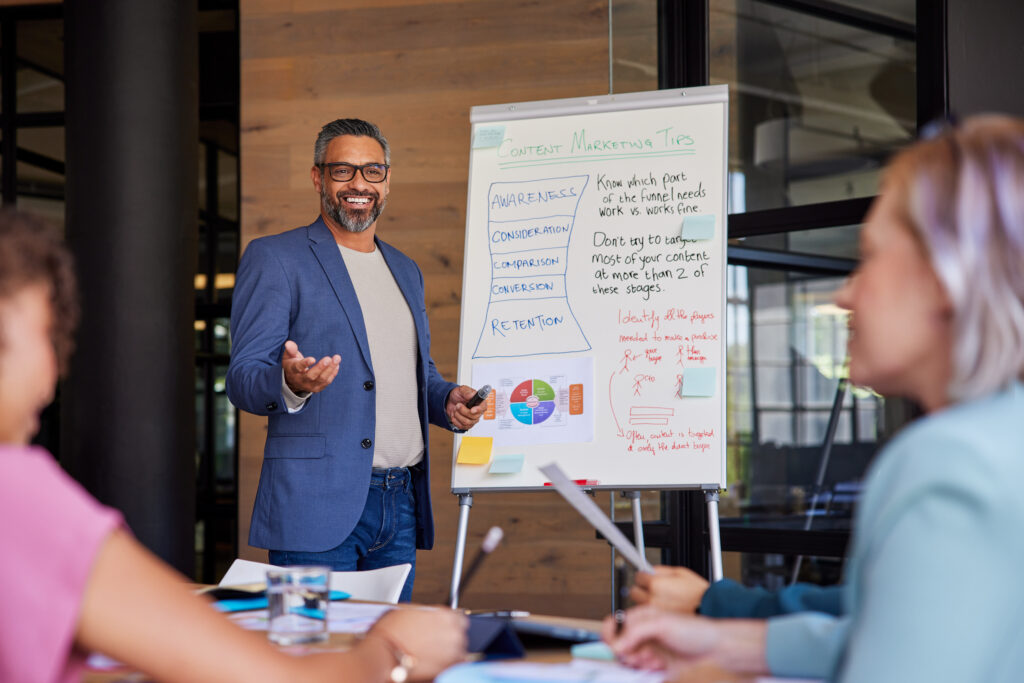 An experienced business growth strategist outlining key stages of company expansion to his team.