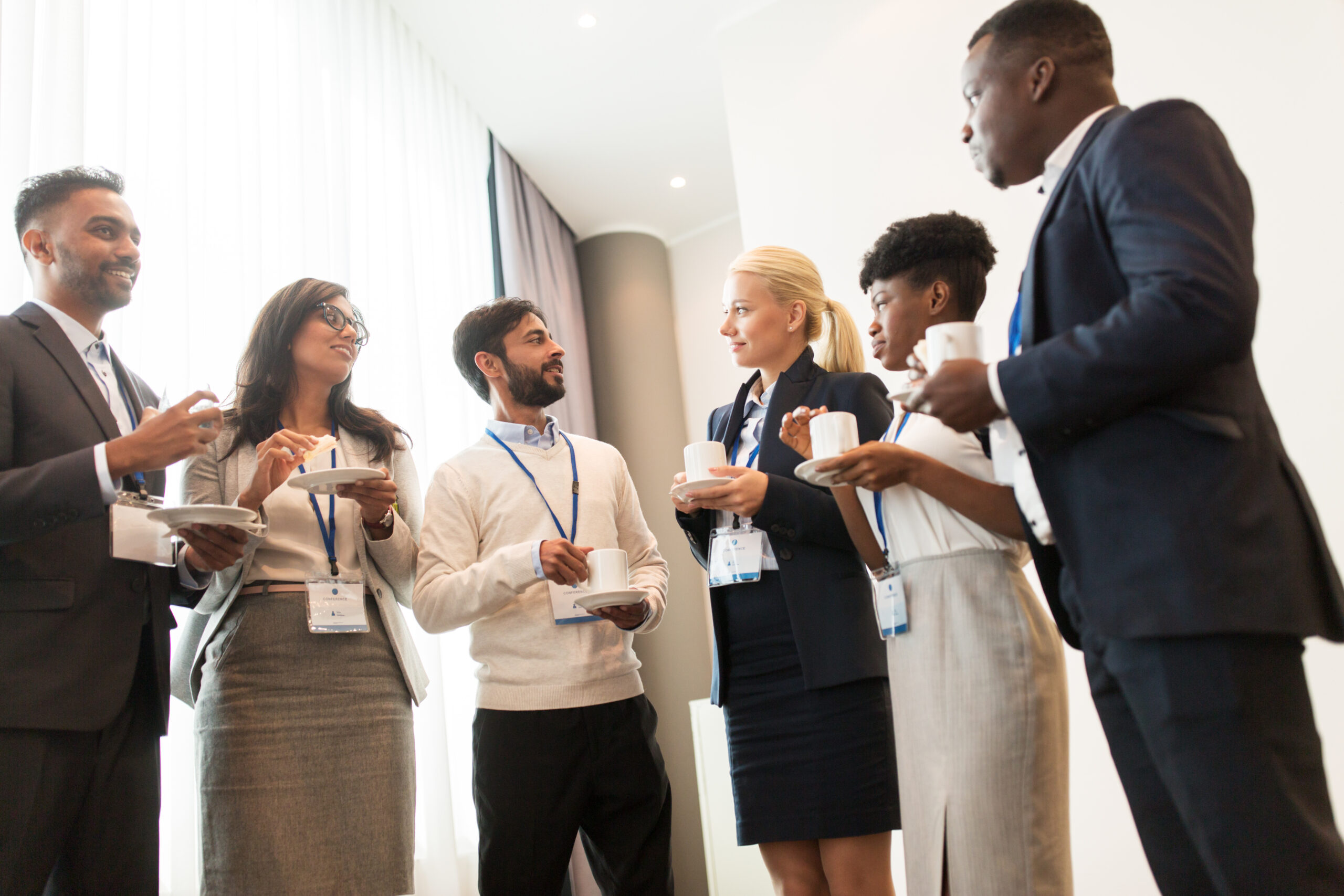 Professionals networking during in-person events and coffee breaks.